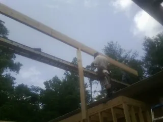 Carpenter setting a ridge beam over a new addition frame — Ice Dam Removal by Roofing Brothers in Blue Mountain