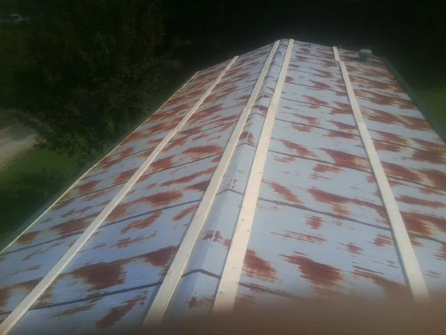 Rusted metal roof panels with new wood purlins before replacement — Storm Damage Roof Repair in Blue Mountain by Roofing Brothers