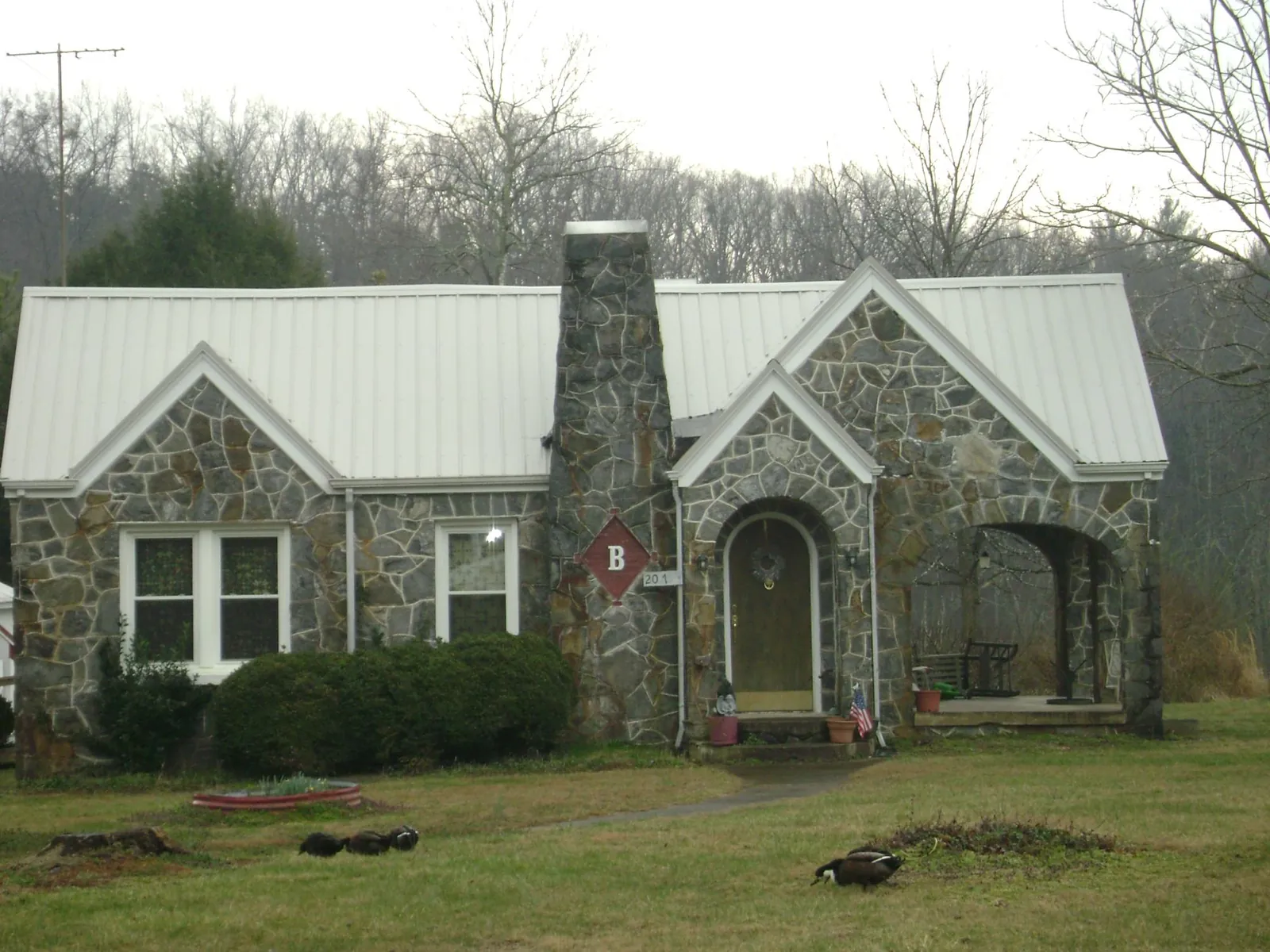 White metal roof on a stone cottage with steep gables in Blue Mountain