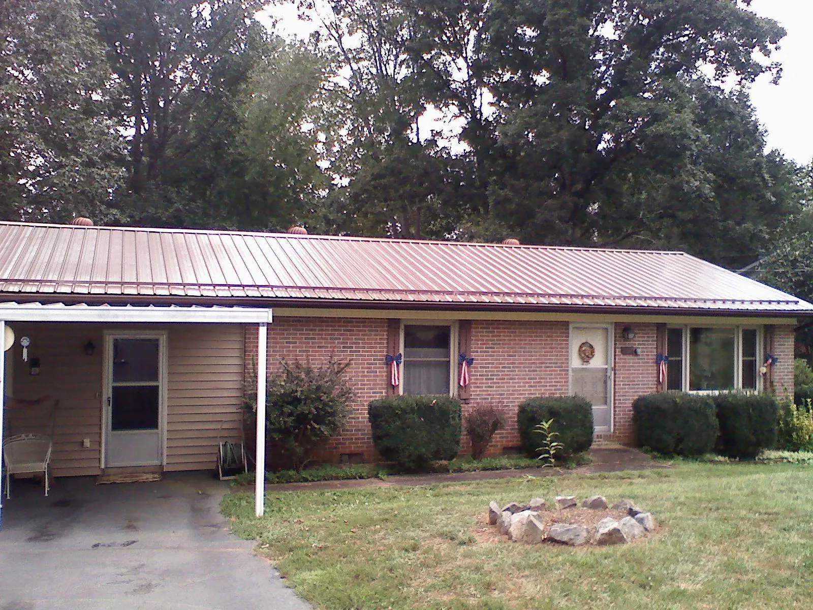 Bronze metal roof and carport on a brick ranch home — Roof Repair work by our crew in Blue Mountain